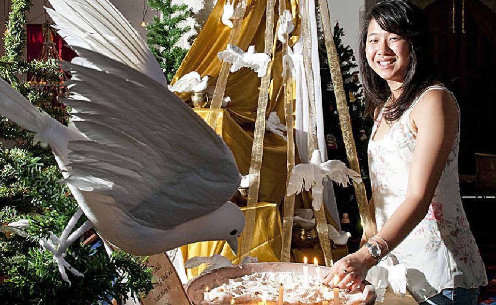Breanna Lancey lights a prayer candle at St Luke’s Anglican Church.
